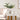 Witte keramische vazen met bloemen op houten tafel in moderne woonkamer.
