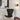Zwarte designstoel, gouden wandlamp, moderne woonkamerinrichting, Scandinavisch interieur.